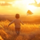 A boy with a kite in hand and the setting sun across an autumn field